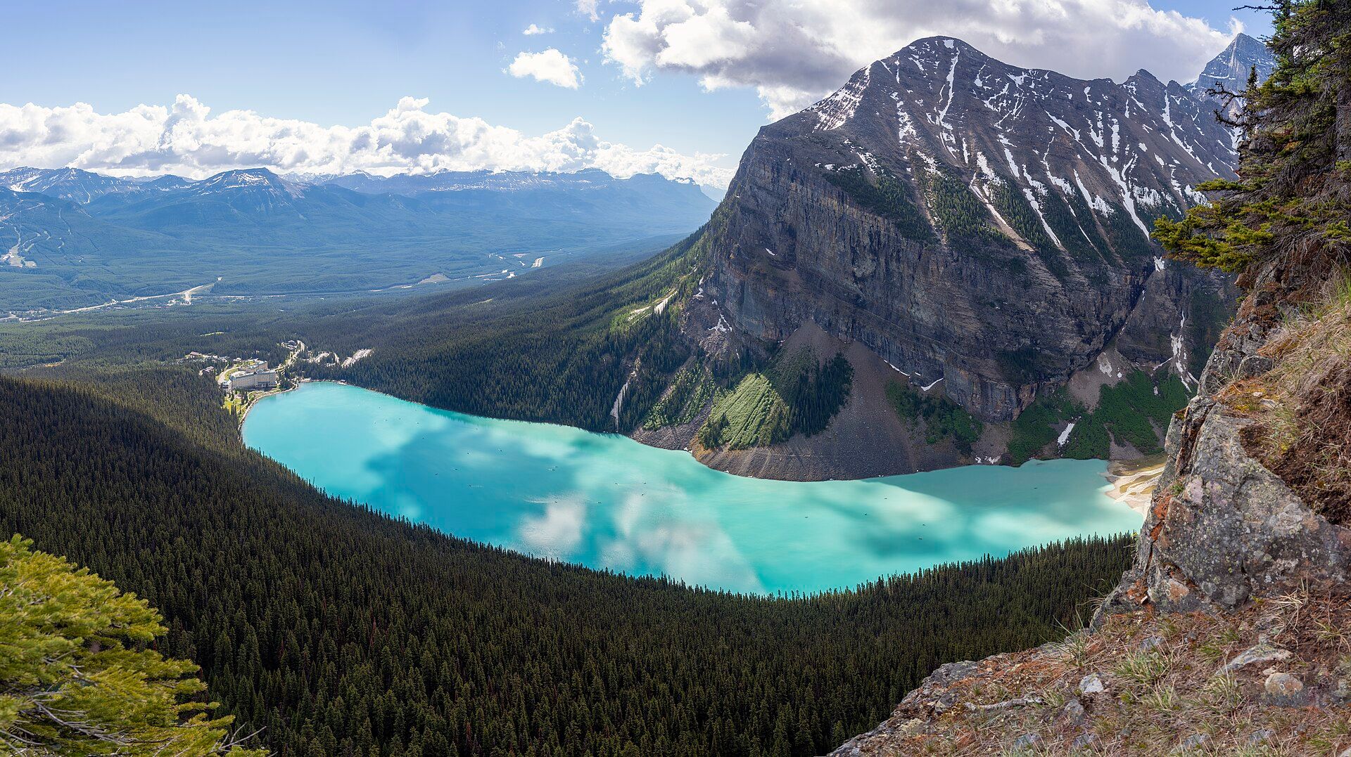 Turquoise Lake Louise seen from above, surrounded by forest and mountains in Banff National Park, Canada