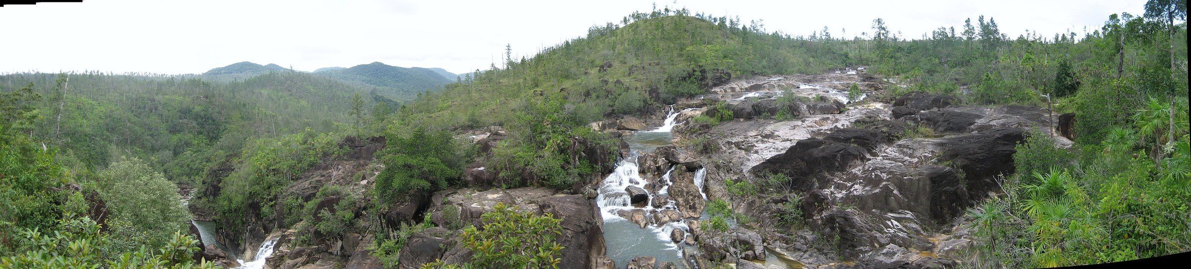 Waterfalls cascading over granite boulders among pine-covered hills in Mountain Pine Ridge, Belize